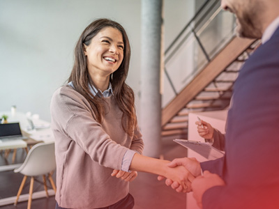 Two people shaking hands in a modern office setting