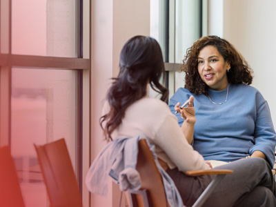 Two people sitting and talking in a modern indoor space