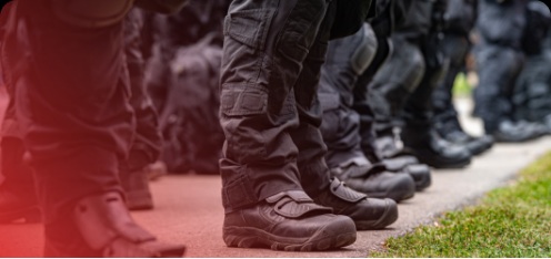 Close-up view of uniformed officers standing in formation, showing their boots and lower legs