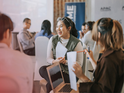 People sitting in a group discussion setting with papers and laptops